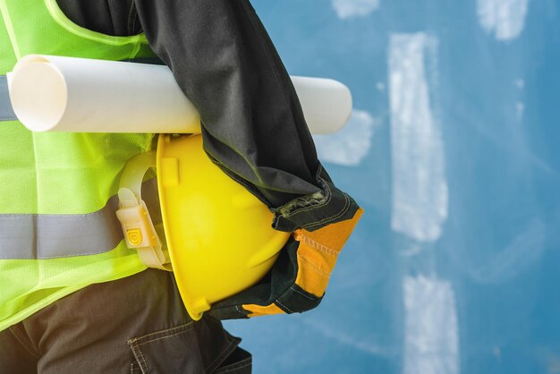 Midsection of engineer holding hardhat