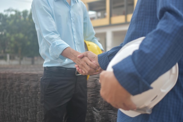 Foto sezione centrale di ingegneri che si stringono la mano all'aperto