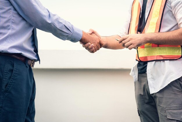 Photo midsection of engineers shaking hands in office