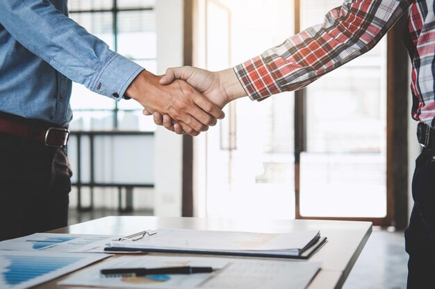 Midsection of engineers shaking hands in office