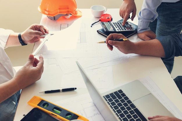 Photo midsection of engineers working over plan in office