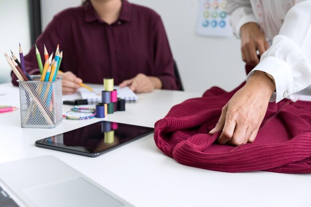 Photo midsection of fashion designers working at desk in office