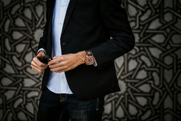 Photo midsection of fashionable man wearing suit while holding sunglasses