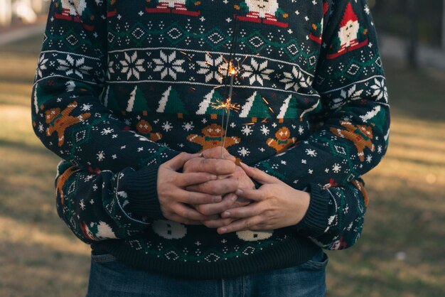 Photo midsection of father with son holding burning sparkle while standing on field