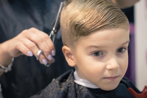 Photo midsection of female hairdresser styling boy hair in salon