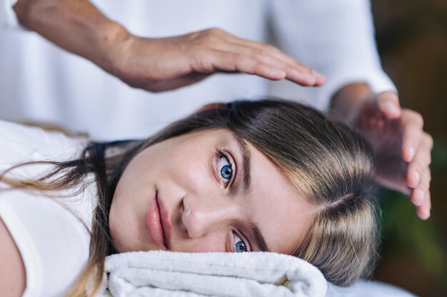 Midsection of female mental health professional gesturing over teenage girl lying on table