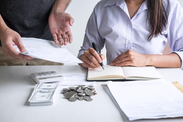 Photo midsection of financial adviser having discussion with coins and banknote on table in office