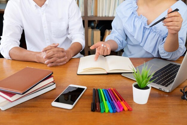 Foto parte centrale di amici che studiano in biblioteca