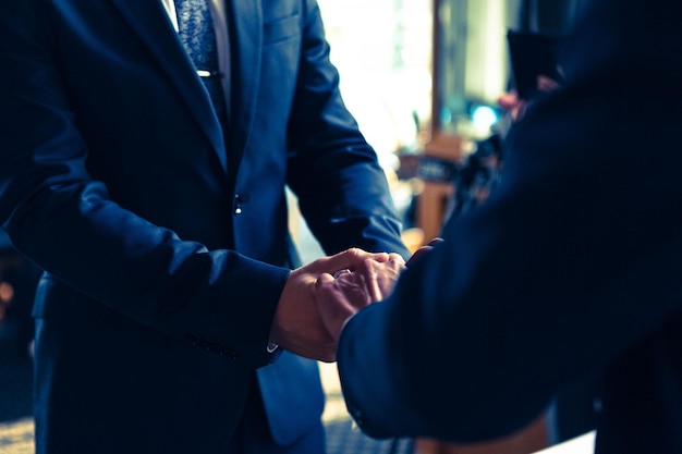 結婚式中に手をつないでいるゲイカップルのミッドセクション