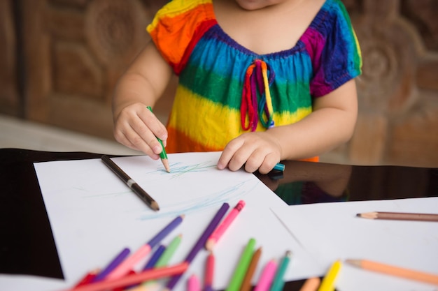 Midsection of girl drawing on paper at table