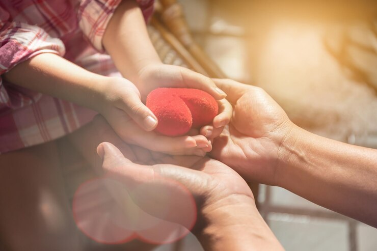 Photo midsection of girl giving red heart to parent