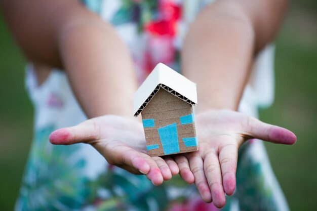 Photo midsection of girl holding model house