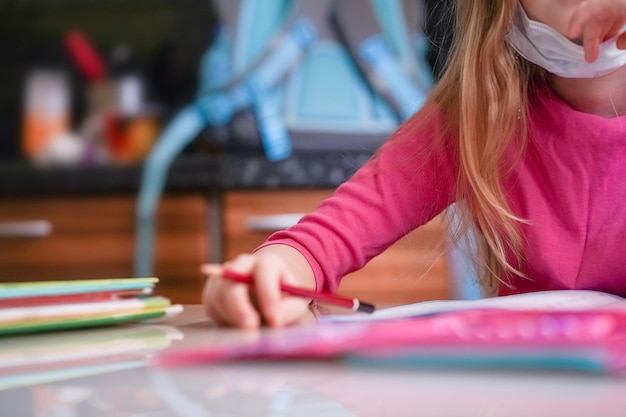 Photo midsection of girl holding pencil on table