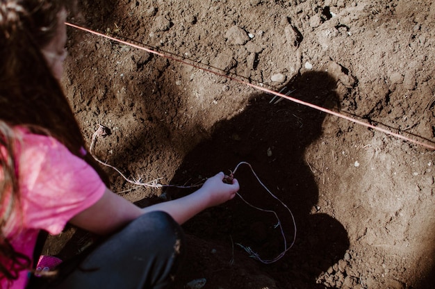 Foto sezione centrale di una ragazza che pianta sul campo