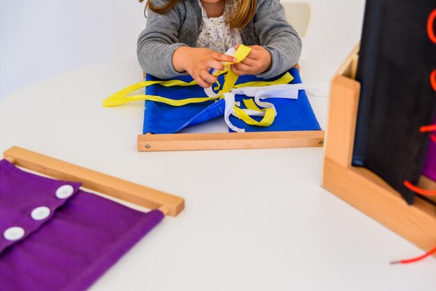 Midsection of girl playing with ribbons while lying on floor