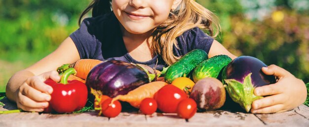 Midsection of girl with fresh vegetables