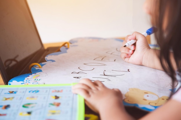 Photo midsection of girl writing on paper