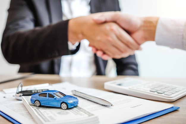 Photo midsection of insurance agent and customer shaking hands on table