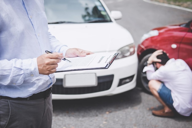 Midsection of insurance agent holding clipboard while standing against car