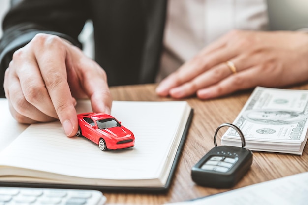 Photo midsection of insurance agent holding toy car
