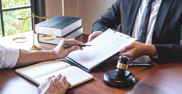 Midsection of lawyer and client discussing on table