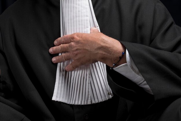 Midsection of lawyer standing against black background