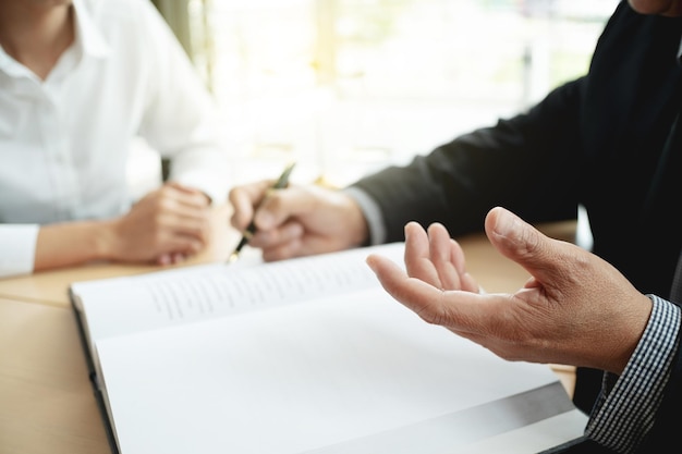 Photo midsection of lawyer writing on book at desk