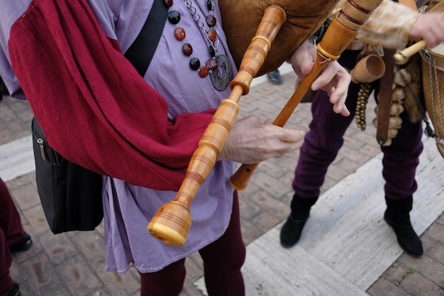 Photo midsection of male street artist playing bagpipe on footpath