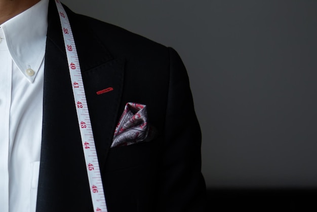 Foto sezione centrale di un uomo in blazer su uno sfondo nero