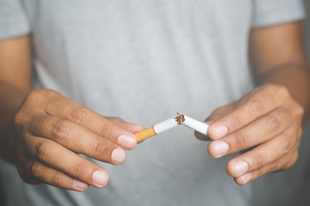 Photo midsection of man breaking cigarette