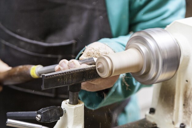 Midsection of man carving wood at workshop