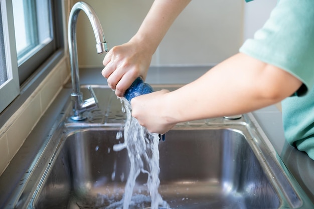 midsection of man cleaning textile in sink at home