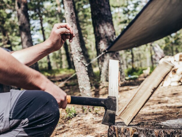 Photo midsection of man cutting wood in forest