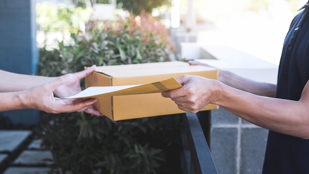 Photo midsection of man delivering package to male customer at gate