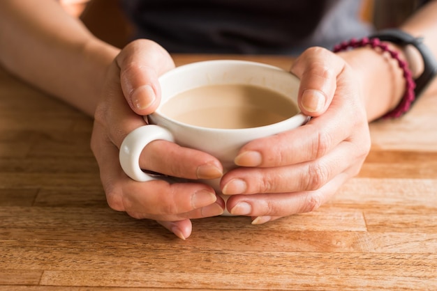 テーブルの上でコーヒーカップを飲んでいる男性のミッドセクション
