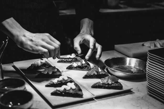 Foto sezione centrale di un uomo che guarnisce il cibo sulla tavola