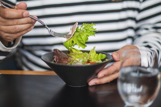 テーブルで食べ物を食べている男性の中央部分