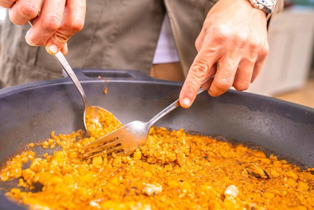 Photo midsection of man having food with fork and spoon in plate at restaurant