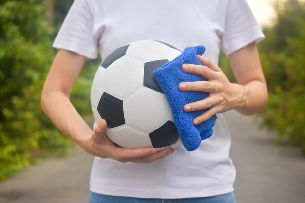 Foto sezione centrale di un uomo che tiene la palla in piedi sul campo da calcio