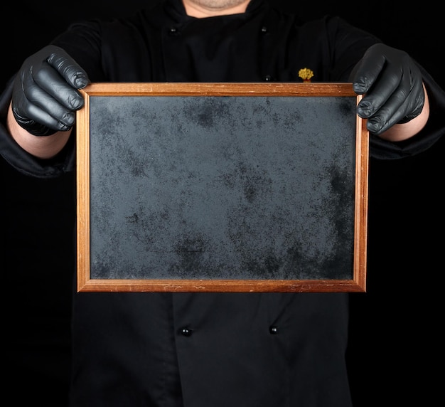 Photo midsection of man holding blank blackboard against black background