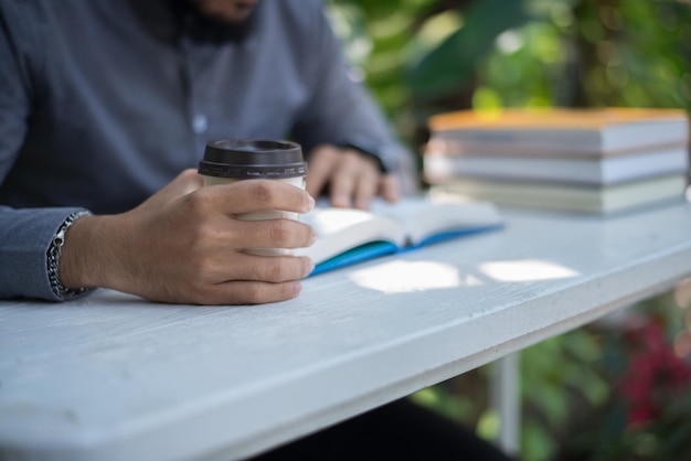 Photo midsection of man holding book while sitting on table