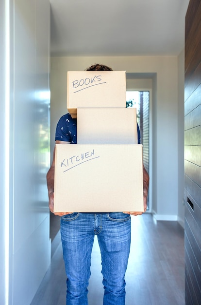 Photo midsection of man holding cardboard boxes at home