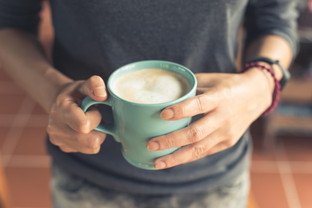 Midsection of man holding coffee cup