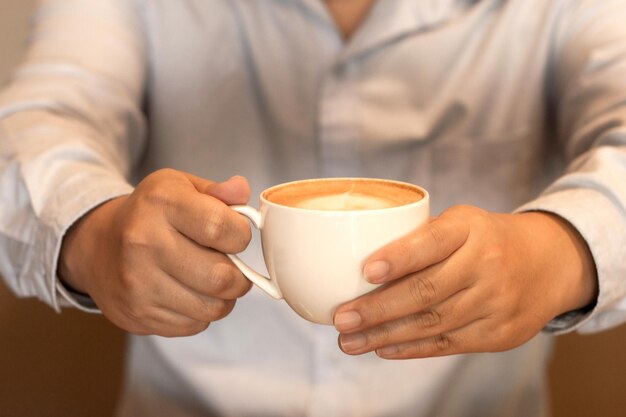 Midsection of man holding coffee cup