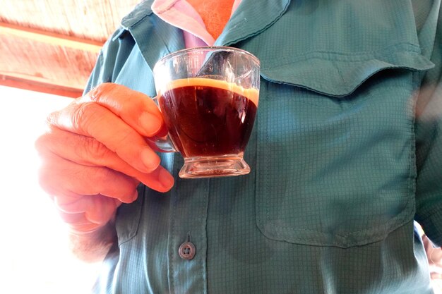 Midsection of man holding coffee glass