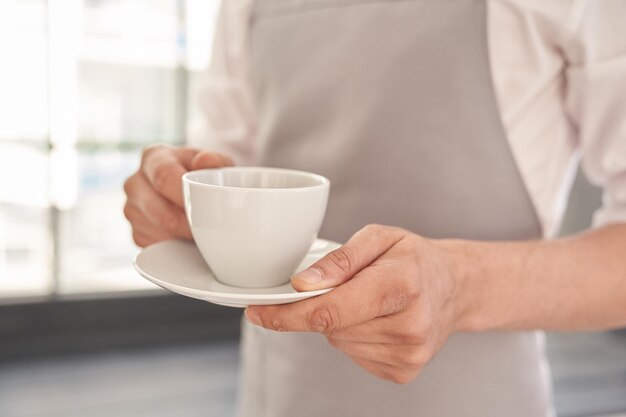 Photo midsection of man holding coffee at home