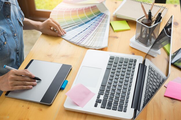 Midsection of man holding color swatches at table in office