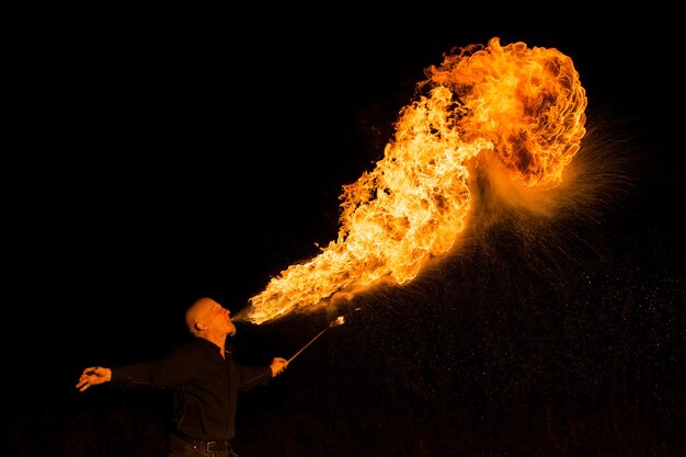 Midsection of man holding fire against black background