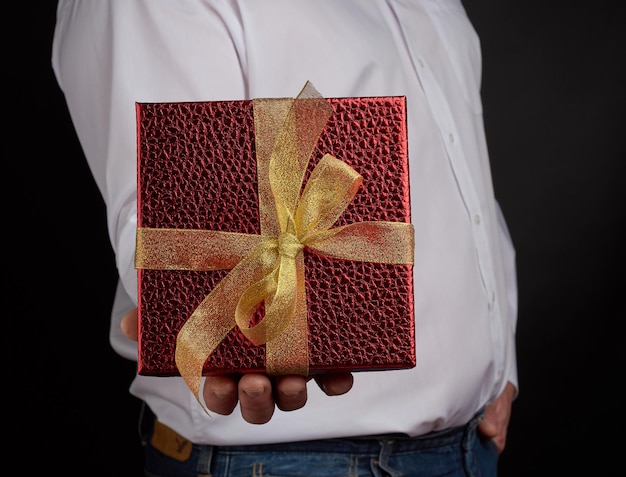 Photo midsection of man holding gift box against black background