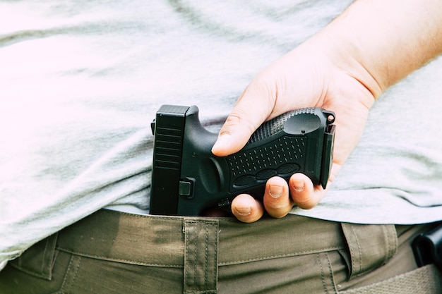 Photo midsection of man holding handgun